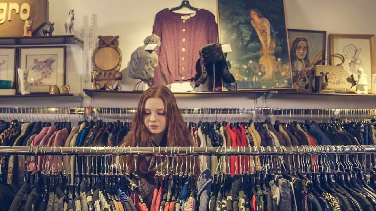 Na zdjęciu dziewczyna szuka ubrań w vintage store.