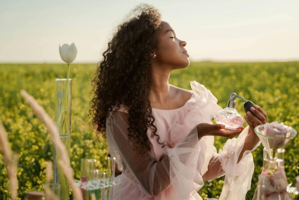 Kobieta psikająca się perfumami. Perfumy damskie na wiosnę. Jaki zapach na wiosnę wybrać?