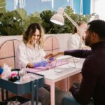 Manicure biznesowy dla mężczyzn. Kosmetyczna wykonująca usługę business manicure