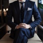 Marcin Pałażej dołącza do Tatuum. Mężczyzna w granatowym garniturze i białej koszulki siedzi na fotelu.