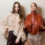 Praca w marketingu mody. Na zdjęciu modelki na backstage zimmermann. Modelka z lewej ubrana w koronkowa bluzke w kolorze pudrowego różu. Modelka z lewej w czerwoną skórzaną kurtkę bomberkę.