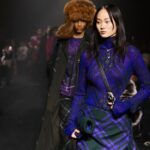 Akcje burberry / Ciemnowłosa kobieta w trakcie wybiegu mody prezentuje granatowy komplet od marki Burberry.