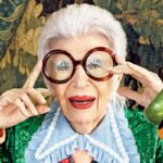 Na zdjęciu Iris Apfel. Zbliżenie na twarz kobiety, na której znajdują się okulary z dużymi okrągłymi oprawkami.