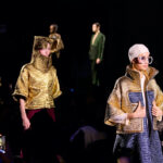 Grzywna dla Pierre Cardin i licencjonobiorcy za łamanie zasad konkurencyjności UE. Na zdjęciu pokaz francuskiej marki Pierre Cardin - na wybiegu widać modelki w oryginalnych lookach mieniących się na złoto, z wzorzystą teksturą.