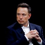 Na zdjęciu przedstawiono Elona Muska podczas oficjalnej inauguracji Donalda Trumpa. Musk, ubrany w elegancki, ciemny garnitur, siedzi z założonymi rękami, co nadaje mu spokojny, ale zarazem skupiony wyraz. Jego poważna twarz podkreśla wagę i doniosłość wydarzenia, w którym uczestniczy. To symboliczne zdjęcie ukazuje moment, w którym biznes i polityka spotykają się na najwyższym szczeblu, zwracając uwagę na rolę Muska jako jednego z najbardziej wpływowych wizjonerów technologicznych współczesnych czasów.