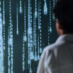 Osoba patrząca na ekran z cyfrowymi kodami, symbolizującymi pracę AI i nowoczesne technologie informatyczne. Future of Jobs Report 2025