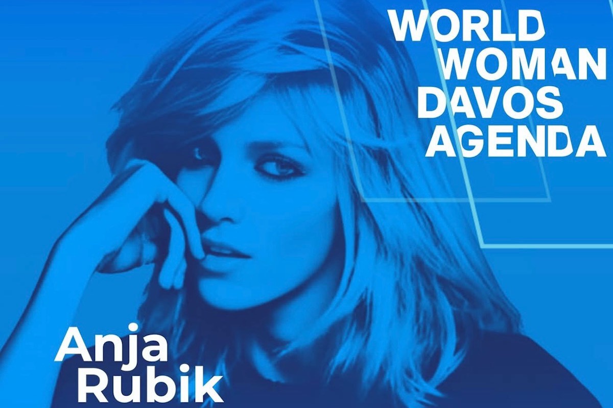 Plakat w odcieniach niebieskiego przedstawiający Anję Rubik, z podpisem 'Anja Rubik' w lewym dolnym rogu. W prawym górnym rogu znajduje się tekst 'World Woman Davos Agenda'. Anja ma długie, rozpuszczone włosy i podpierając głowę dłonią, patrzy w dal.