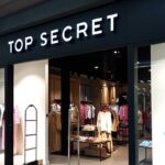 Witryna sklepu Top Secret, należąca do łódzkiej spółki Redan, zajmująca centralną część kadru. Manekiny stanowią podstawowe wyposażenie odzieży, a w tle widać gustownie zaaranżowane kuchnie. W związku z wydaniem decyzji o rozwiązaniu firmy zdjęcie ilustruje niepewność losu pojedynczego pracownika. W Redan zwolnienia grupowe są możliwe.