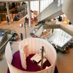 Sadyba Best Mall. Zdjęcie przedstawia przykładowe centrum handlowe. Widok z góry na księgarnię i ruchome schody.