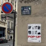 Ulica Rue Sainte Cécile w Paryżu z widoczną tabliczką z nazwą ulicy oraz znakiem zakazu parkowania i ostrzeżeniem o odholowywaniu pojazdów. Na ścianie widoczny jest plakat promujący pop-up „Closet Sale” z polskimi markami, odzieżą second-hand i markami influencerek. Plakat zawiera zdjęcia marek i informację o terminie wydarzenia: 13–15 lutego 2025 roku, w godzinach 10:00–18:00.