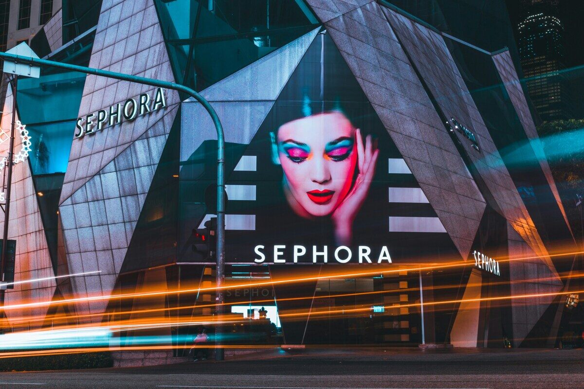 Sephora Kids. Zdjęcie przedstawia budynek sklepu Sephora nocą. Oprócz szyldu marki widać reklamę z kobietą z kolorowym makijażem oczu.