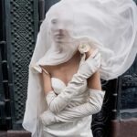 Magda Butrym nawiązała współpracę z Vestiaire Collective, gdzie będzie sprzedawać archiwalne projekty za ułamek ceny. Na zdjęciu kampania Butrym - modelka w białej sukience, z widocznym charakterystycznymi elementami dla projektantki - różami.