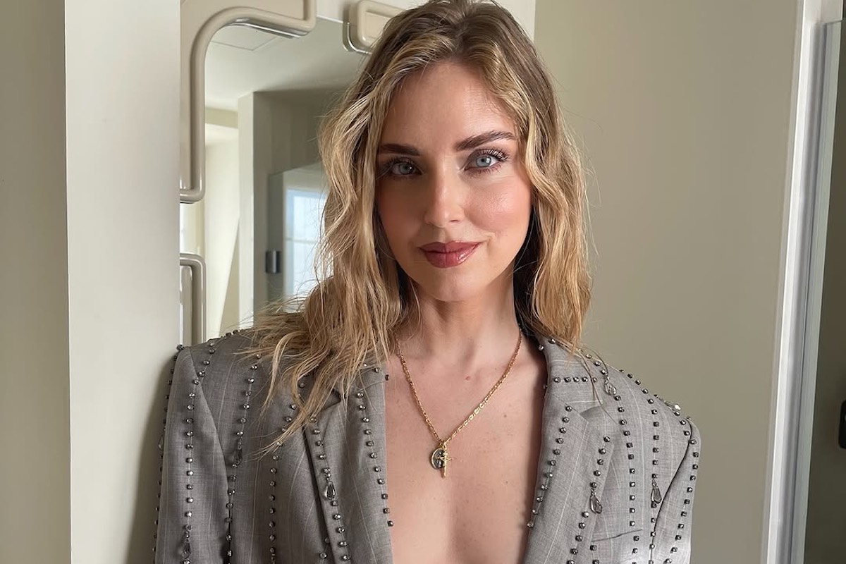 Chiara Ferragni straciła 10 milionów euro. Na zdjęciu włoska influencerka Chiara Ferragni - blondynka z rozpuszczonymi falowanymi włosami. Jest ubrana w szarą marynarkę z głębokim dekoltem wysadzaną kryształkami.