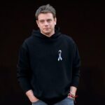 Jonathan Anderson odchodzi z Loewe po 11 latach. Na zdjęciu projektant w czarnej bluzie z przypinką z flagą Ukrainy.