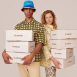 Zalando wyniki finansowe. Chłopak i dziewczyna trzymający w rękach paczki z zamówieniami Zalando.
