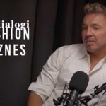Łukasz Jemioł gościem podcastu Fashion Biznes Dialogi. Na zdjęciu polski projektant ubrany w białą koszulę, w studio podcastu.