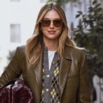 Chiara Ferragni przejmuje kontrolę nad swoją marką. Pozuje na ulicy w okularach przeciwsłonecznych, kardiganie i skórzanej marynarce.