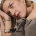 Lara Gessler w kampanii Tous MMC Studio, ubrana w zieloną sukienkę i charakterystyczną biżuterię Tous. Artystyczne ujęcie modelki w stylizacji MMC Studio z bransoletkami TOUS – moda i biżuteria w harmonii.