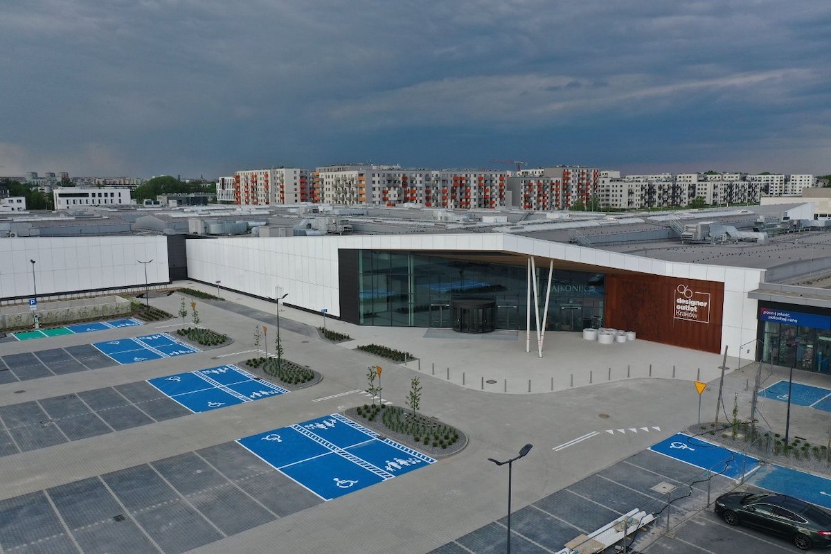 Designer Outlet Kraków widok z góry na budynek centrum handlowego i parking.