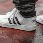 Zbliżenie na białe buty Adidas z charakterystycznymi trzema czarnymi paskami, o które toczy się spor – Steve Madden złożył pozew przeciwko marc adidas.