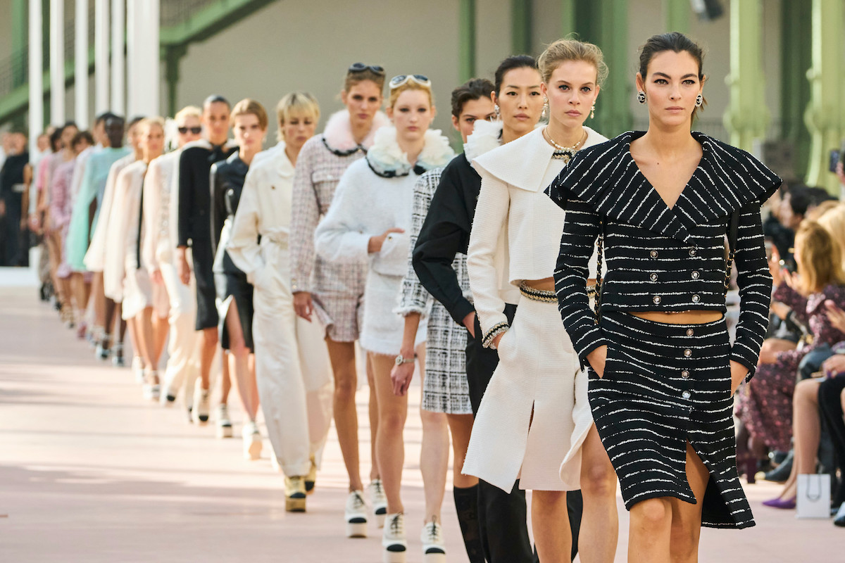 Chanel inwestuje w modę zrównoważoną. Na zdjęciu pokaz chanel FW2025 modelki idące w rzędzie po wybiegu.