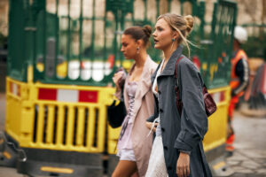 Warsaw Fashion Week pod znakiem zapytania. Moliera 2 wycofuje się z organizacji. Na zdjęciu dwie modelki podczas tygodnia mody idące ulicą.