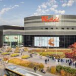 Kładka przy Galerii Mokotów zniknie po 25 latach. Na zdjęciu duże centrum handlowe o nazwie 'Westfield Mokotów' z nowoczesną architekturą: zakrzywiona fasada w odcieniach szarości i czerni, duże szklane witryny. Na budynku wyróżnia się czerwone logo 'Westfield'.