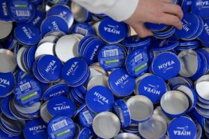 Nivea fabryka wyprodukuje 500 mln kosmetyków. Na zdjęciu opakowania na krem Nivea z widocznym logo na wieczku, w niebieskim kolorze.