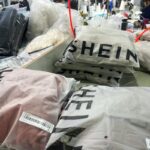 Shein analiza. Na zdjęciu worki z ubraniami z Shein z widocznym logo marki.