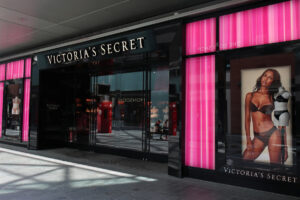 Sklep Victoria's Secret Kraków. Zdjęcie sklepu amerykańskiej marki z czarno-różową elewacją i reklamą kobiety w bieliźnie. Zdjęcie nawiązuje do otwarcia nowego sklepu Victoria's Secret w Polsce.