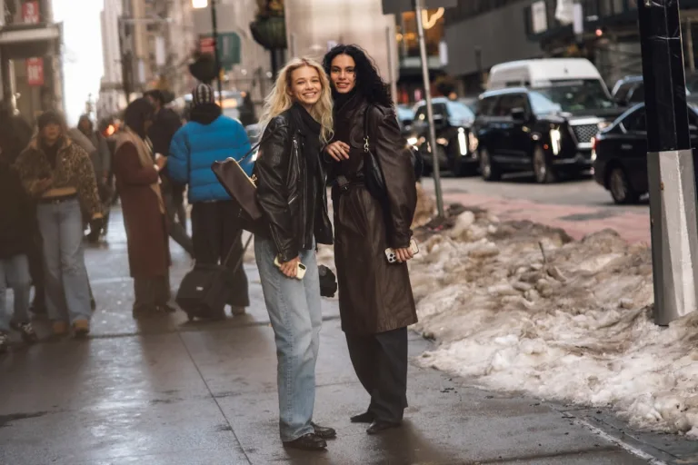 Przejęcie Depop przez eBay. Dwie kobiety w stylizacjach street style w skórzanych kurtkach i płaszczach na zaśnieżonej ulicy miasta.