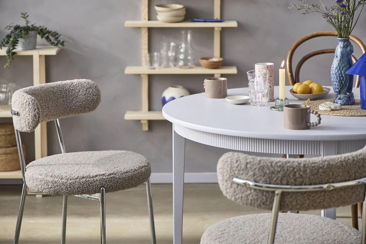 Søstrene Grene Polska sklep online, aplikacja. Skandynawska aranżacja wnętrza z meblami i dodatkami Søstrene Grene – jasny stół, tapicerowane krzesła i dekoracje w minimalistycznym stylu. Inspiracje do domu dostępne w ofercie marki online.