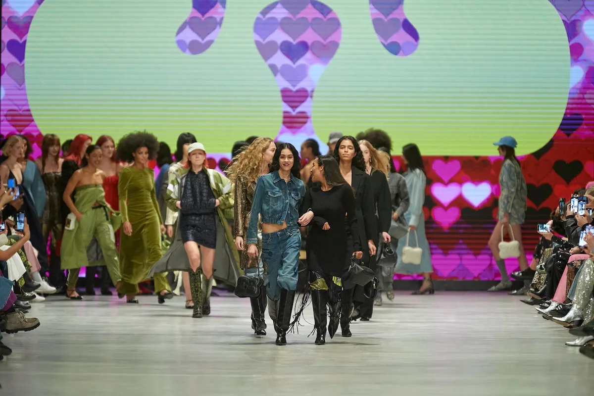Finał pokazu Ganni – modelki na wybiegu w kolorowych stylizacjach na tle graficznej scenografii.