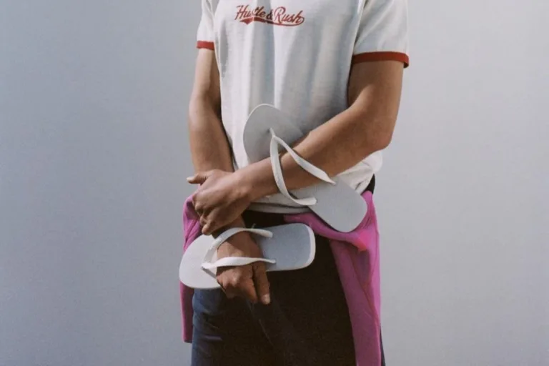 Białe japonki z kolekcji Havaianas x Zara trzymane w dłoni w casualowej stylizacji. Minimalistyczny model w jasnym kolorze wpisuje się w estetykę letniego basicu. Klapki idealne na sezon lato 2026.