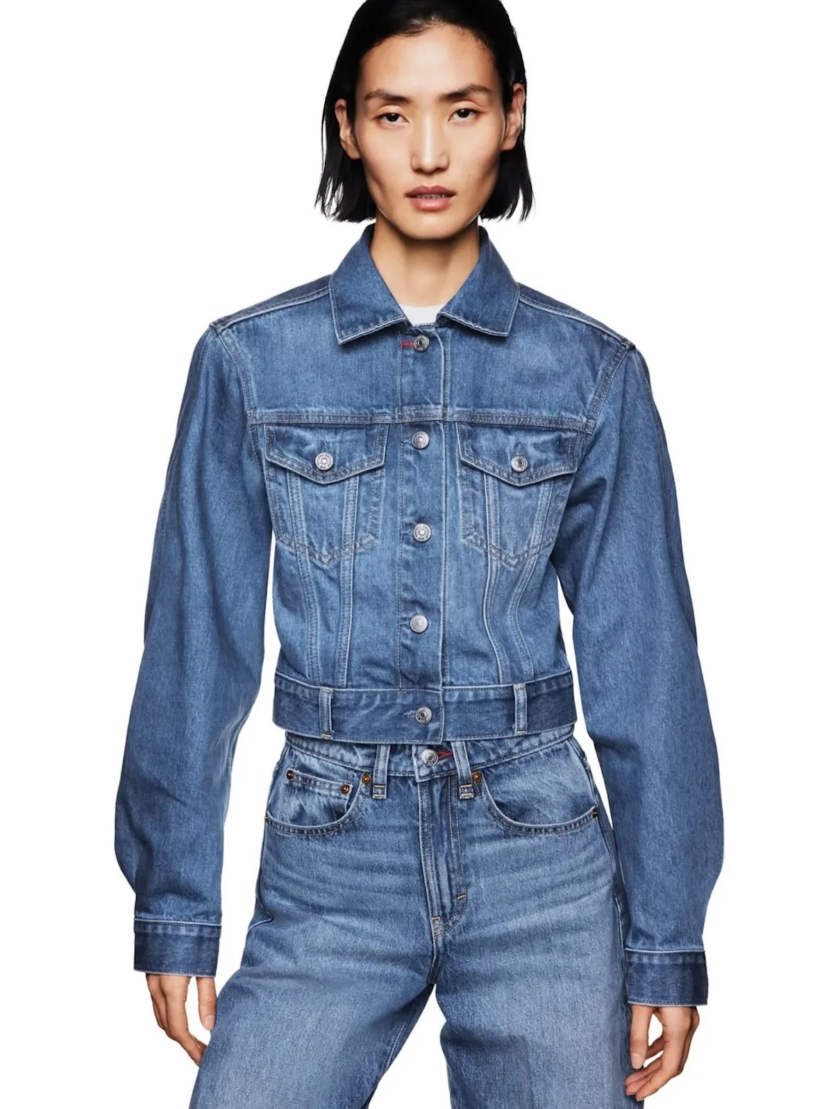 Dopasowana kurtka jeansowa z kolekcji Victoria Beckham x Gap w klasycznym niebieskim odcieniu. Model o skróconym kroju z wyraźnie zaznaczoną talią i minimalistycznymi detalami wpisuje się w estetykę nowoczesnej garderoby bazowej.