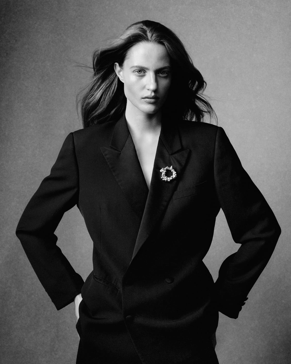 Modelka w czarnym garniturze z broszką CHYLAK Jewellery inspirowaną formą sękacza