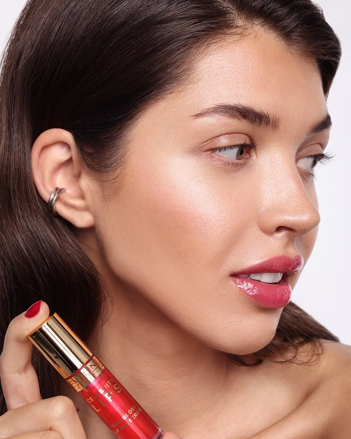 Modelka prezentuje błyszczyk do ust Eveline Cosmetics o efekcie glossy i intensywnym kolorze. Zdjęcie wpisuje się w viralowy fenomen „Eweliny Kosmetycznej”, który przywrócił marce popularność wśród młodszych użytkowników.