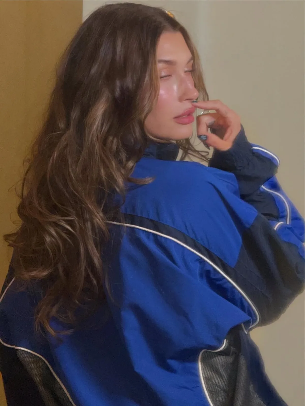 Hailey Bieber w niebieskiej, vintage kurtce Lotto Sport Italia w zbliżeniu, podkreślającym sportowy charakter stylizacji. Archiwalny model z charakterystycznymi panelami i liniami wpisuje się w trend powrotu do estetyki lat 90. To właśnie takie ujęcia napędziły ponowne zainteresowanie marką Lotto.