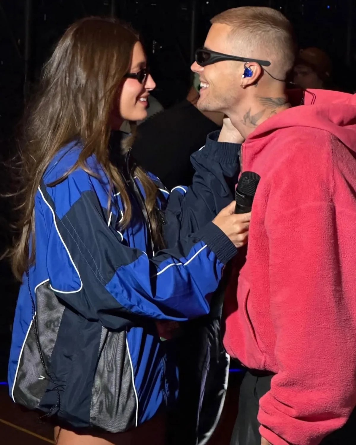 Hailey Bieber w sportowej, vintage kurtce Lotto Sport Italia podczas festiwalu Coachella, uchwycona w trakcie rozmowy z rozmówcą. Stylizacja łączy luźny, streetwearowy vibe z archiwalnym designem marki. To właśnie ten look wywołał ponowne zainteresowanie Lotto w sieci.