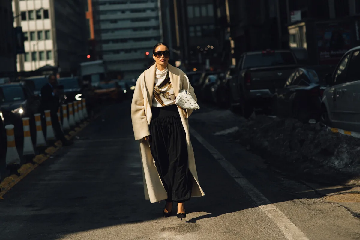 Podwyżki cen ubrań 2026. Stylowa kobieta na ulicy w eleganckim płaszczu podkreśla zmieniający się rynek mody w obliczu podwyżek cen ubrań w 2026 roku. Rosnące koszty produkcji i surowców sprawiają, że konsumenci coraz częściej wybierają jakość zamiast ilości.