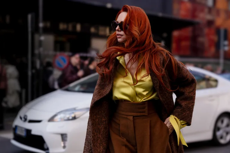 Elegancka kobieta w stylizacji premium na tle miejskiej ulicy oddaje ducha klienta luksusowego, na którym chce się skupić Saks Global po restrukturyzacji. Nowa strategia firmy zakłada koncentrację na najbardziej wymagających klientach i redefinicję doświadczenia zakupowego w segmencie high-end.