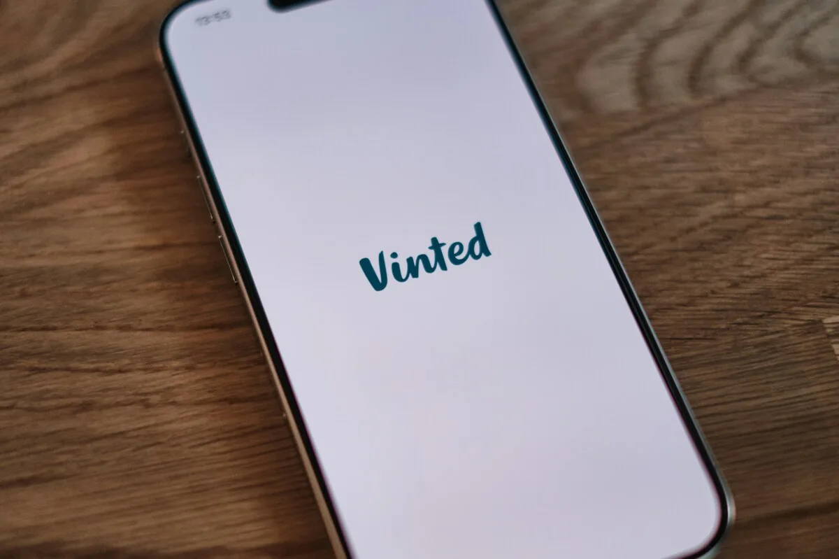 Smartfon z widoczną aplikacją Vinted na ekranie, symbolizujący rosnącą popularność platformy resale. Zdjęcie nawiązuje do tematu wyniki finansowe Vinted 2025, które pokazują dynamiczny rozwój aplikacji i wzrost liczby użytkowników.