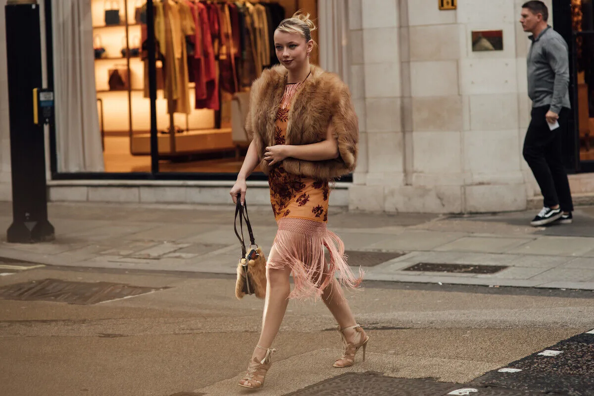 Stylowo ubrana kobieta na ulicy w eleganckiej stylizacji, nawiązującej do trendów modowych i świadomej konsumpcji. Zdjęcie dobrze oddaje kontekst rynku resale i rosnącego znaczenia platform takich jak Vinted, co wpisuje się w temat wyniki finansowe Vinted 2025 i zmieniających się nawyków zakupowych.