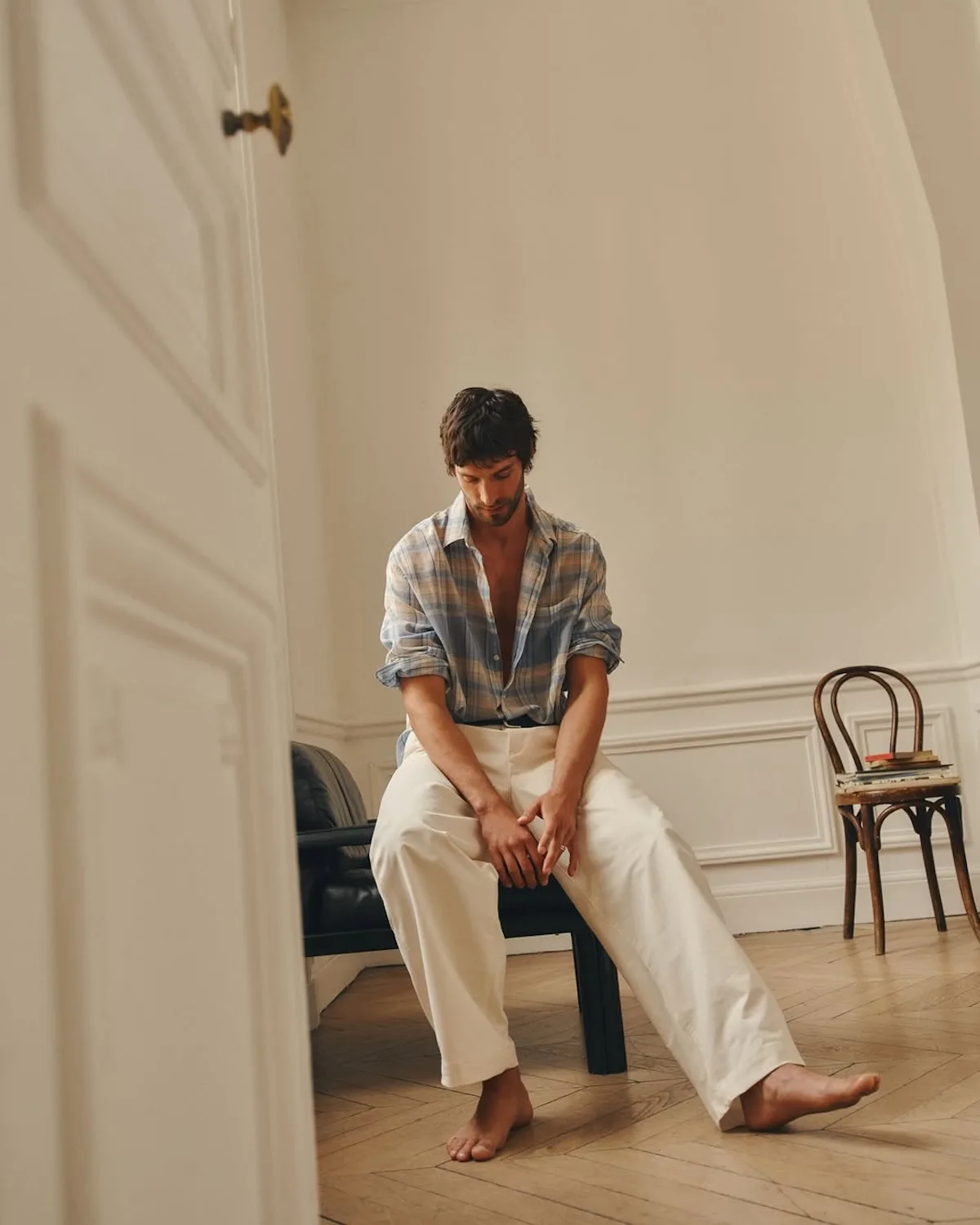 Model w minimalistycznym wnętrzu prezentuje styl Zara Man – luźna koszula i jasne spodnie podkreślają bardziej selektywne, premium podejście do mody męskiej.