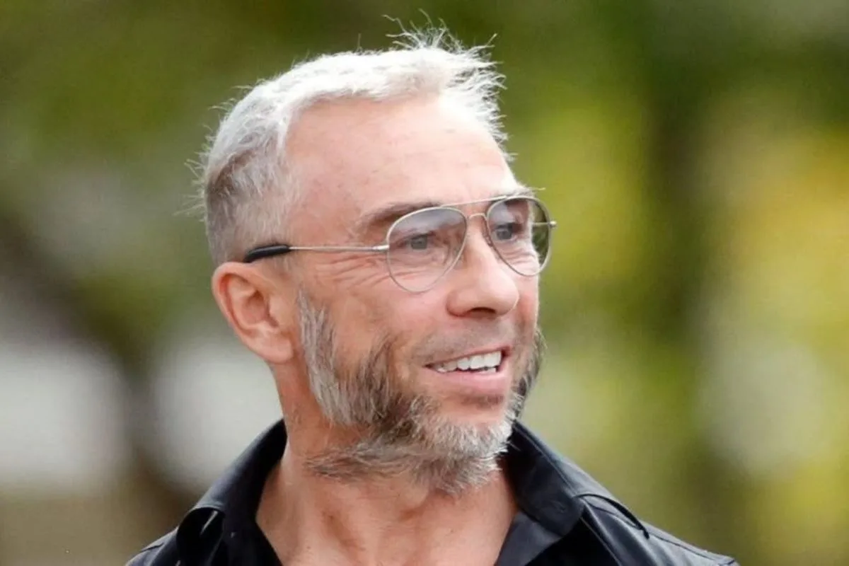 James Holder uznany za winnego. Na zdjęciu widoczny jest uśmiechnięty mężczyzna w okularach, z krótkimi siwymi włosami i zarostem. Portret ilustruje artykuł dotyczący sprawy sądowej związanej ze współzałożycielem marki Superdry.