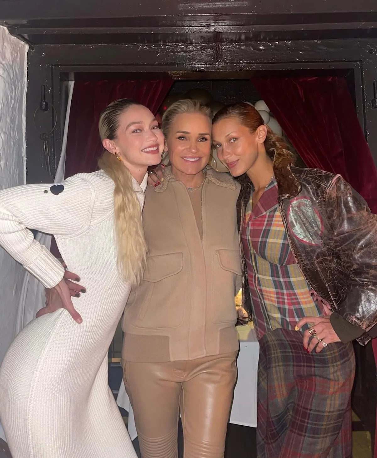 Yolanda Hadid stoi między córkami, Gigi Hadid i Bellą Hadid, podczas prywatnego spotkania. Fotografia ilustruje rodzinę, która silnie wpłynęła na modeling w erze mediów społecznościowych.