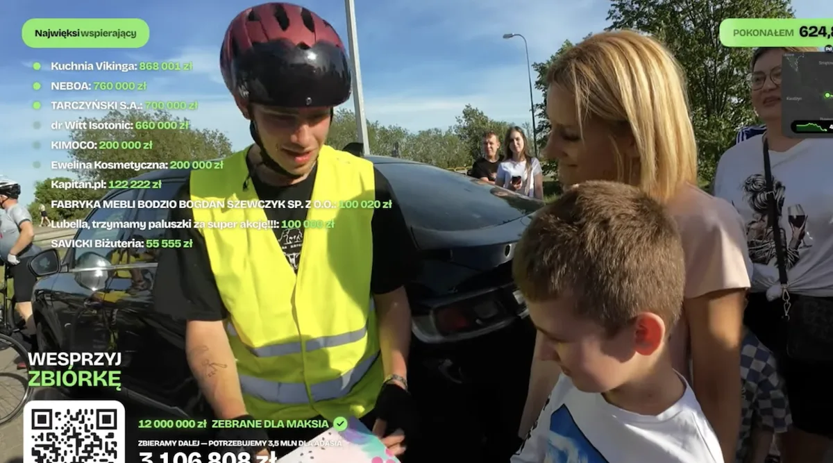 Łatwogang na rowerze - screen z transmisji live, gdzie Łatwogang przekazuje 12 mln dla leczenie Maksa z DMD