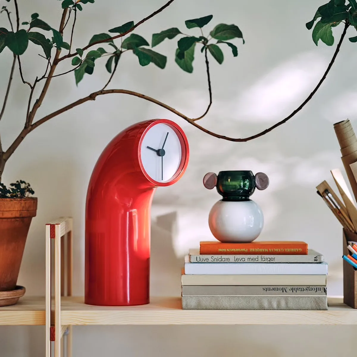 Czerwony zegar stołowy zaprojektowany przez Martę Krupińską dla IKEA PS 2026. Designerski projekt inspirowany formą peryskopu łączy funkcję użytkową z dekoracyjną.
