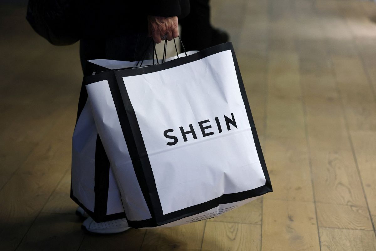 Shein zamyka sklep stacjonarny w Paryżu. Torby zakupowe z logo Shein niesione przez klienta. Chiński gigant ultra fast fashion ma zakończyć działalność swojego pierwszego sklepu stacjonarnego w paryskim BHV Marais.