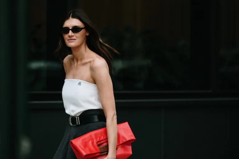 Wyniki finansowe LPP Q1 2026. Kobieta w minimalistycznej stylizacji z czarną spódnicą, białym topem i czerwoną torebką. Nowoczesny look inspirowany trendami fashion i stylem miejskim.